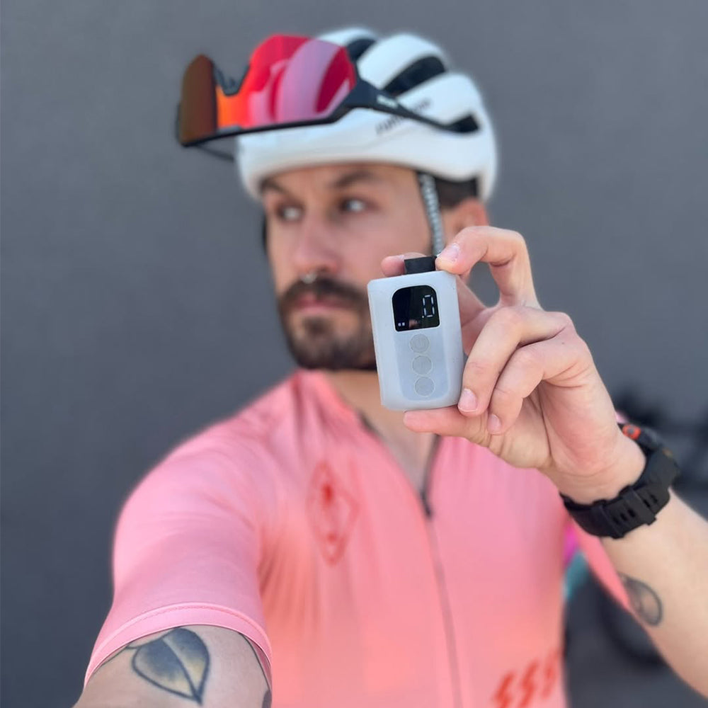 Cyclist @martinsramza holding the BSCOBBER A3Max electric bicycle pump – sleek, compact mini inflator designed for precise and efficient bike tire inflation on the go