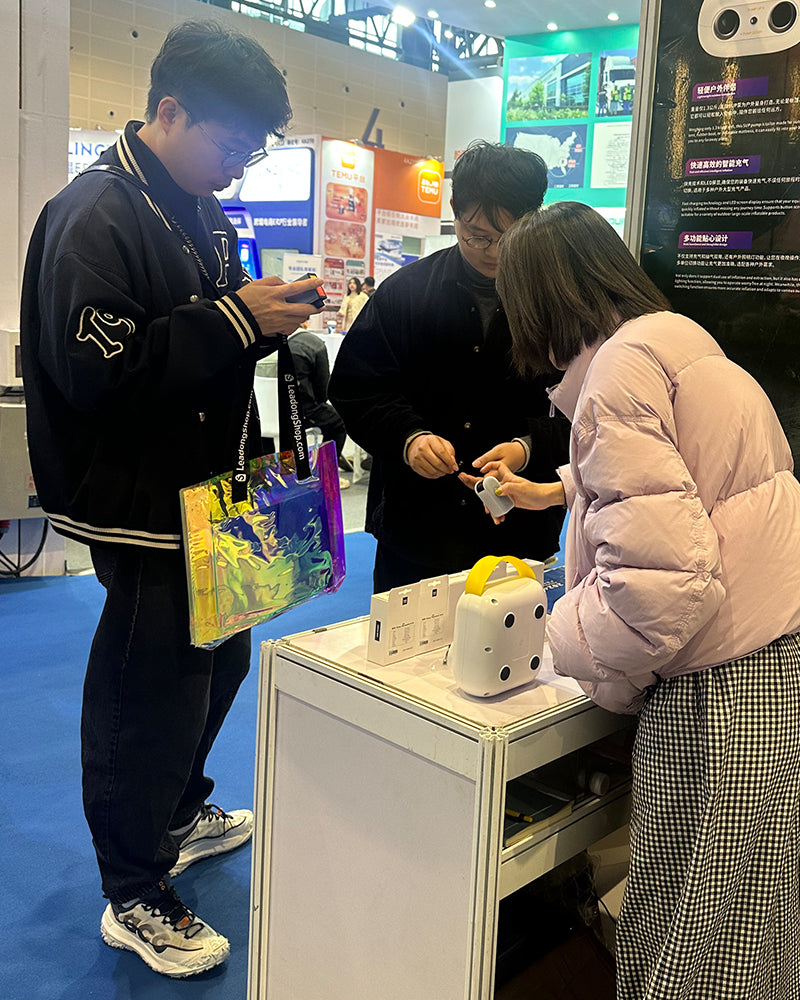 In-person demonstration of BSCOBBER mini air pumps during outdoor gear exhibition, attracting professional buyers and media